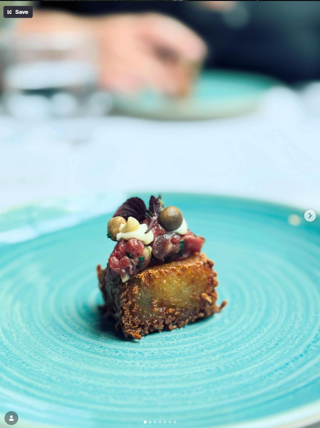 Illustrative crisp square topped with garnish on a turquoise plate